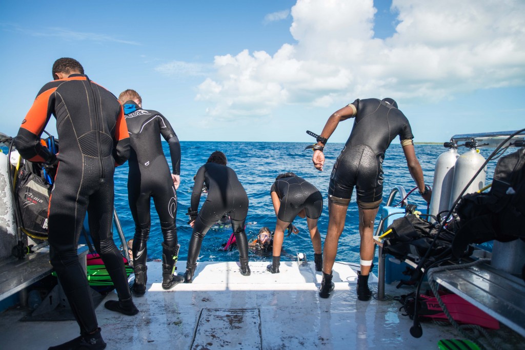 Students helping each other back on the Cobia before another dive