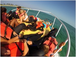 Students relaxing on the Cobia on the way out to The Barge.